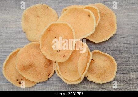 Cracker di gamberi (krupuk) su sfondo di legno Foto Stock