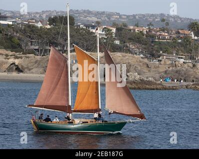 Barca a vela tradizionale che parte dal porto di Newport Beach con vista sul mare Case California Stati Uniti Foto Stock