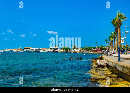 PAPHOS, CIPRO, 18 AGOSTO 2017: La gente sta godendo una giornata di sole su una passeggiata sul mare a Paphos, Cipro Foto Stock