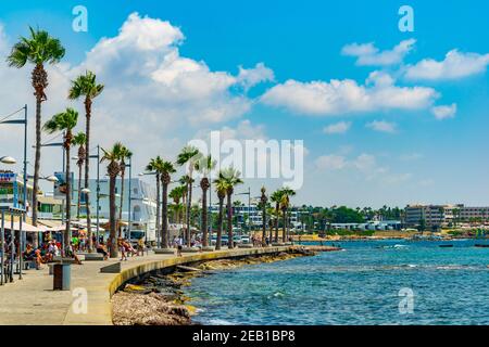 PAPHOS, CIPRO, 18 AGOSTO 2017: La gente sta godendo una giornata di sole su una passeggiata sul mare a Paphos, Cipro Foto Stock