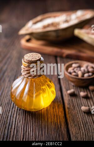 Olio di semi di Baobab in bottiglia di vetro per una pelle sana e. capelli su sfondo rustico di legno Foto Stock