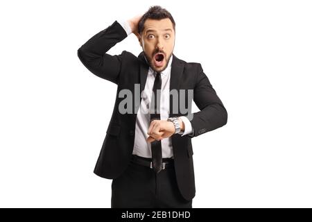 Uomo d'affari scioccato che controlla il suo orologio da polso e tiene la testa isolata su sfondo bianco Foto Stock