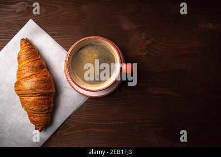 Caffè e croissant su sfondo di legno Foto Stock