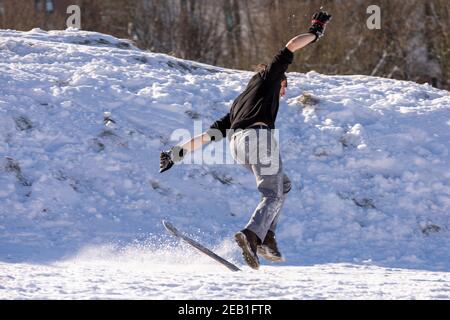 Un giovane che cade da uno snowboard improvvisato vicino Salisbury Stracci Foto Stock