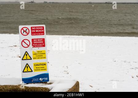 Cartello segnaletico sulla spiaggia a Southend on Sea, Essex, UK, con neve da Storm Darcy. L'estuario del Tamigi e il molo oltre. Non ci sono cani in spiaggia, non ci sono esche che scavano Foto Stock
