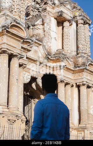 Giovane uomo in piedi di fronte alla chiesa di El Carmen Antigua Guatemala - turista osservando l'architettura della città coloniale In Guatemala Foto Stock