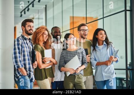 Foto di gruppo di giovani entusiasti con notebook Foto Stock