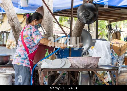 AYUTTHAYA, THAILANDIA, GIUGNO 03 2020, UNA donna lava i piatti in un ristorante di strada Foto Stock