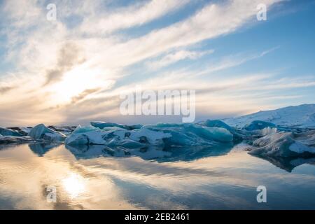 Tramonto sopra gli iceberg sulla laguna del ghiacciaio Jokulsarlon a sud Islanda Foto Stock