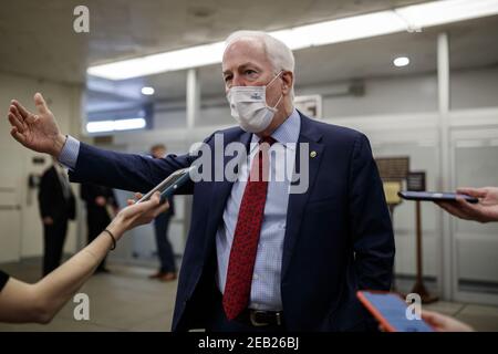 Washington, Stati Uniti. 11 Feb 2021. Il senatore John Cornyn, un repubblicano del Texas, indossa una maschera protettiva mentre parla ai membri della stampa nella metropolitana del Senato alla fine del terzo giorno del secondo processo di impeachment al Campidoglio a Washington, DC giovedì 11 febbraio 2021. Le argomentazioni saranno presentate oggi nel processo di impeachment dell’ex presidente Donald Trump. Pool Photo by Ting Shen/UPI Credit: UPI/Alamy Live News Foto Stock