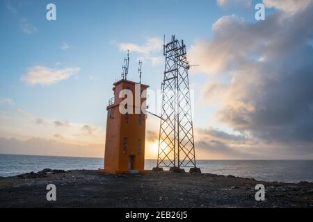 Il faro di Hvalnes nell'Islanda orientale con l'atlantico oceano sullo sfondo Foto Stock