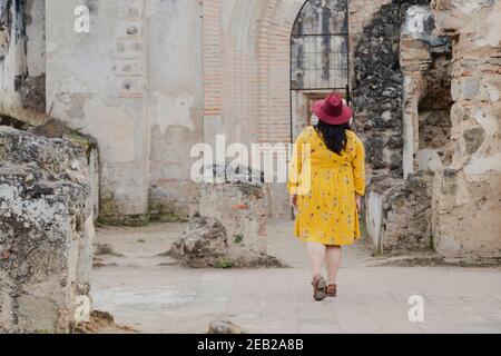 Donna ispanica in vacanza a piedi attraverso le rovine della Cattedrale di Santiago Antigua Guatemala - turista godendo la sua vacanza in antiche rovine Foto Stock