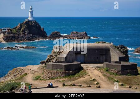 Una seconda Guerra Mondiale tedesco Bunker in primo piano con Corbiere Lighthouse formando il fondale in Jersey,Isole del Canale Foto Stock