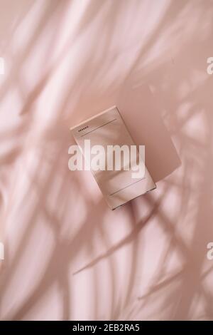 Confezione di cosmetici minimal. Rosa pastello, luci e ombre dalle foglie. Concetti del pacchetto del marchio, dall'alto Foto Stock