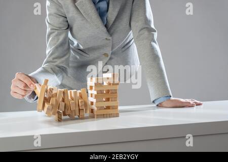 Uomo d'affari che rimuove il blocco di legno dalla torre Foto Stock