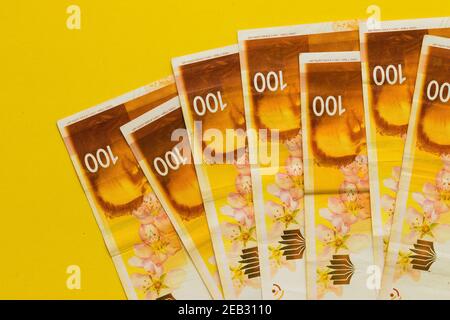 Un sacco di nuove banconote israeliane di un centinaio di sicli, sfondo giallo Foto Stock