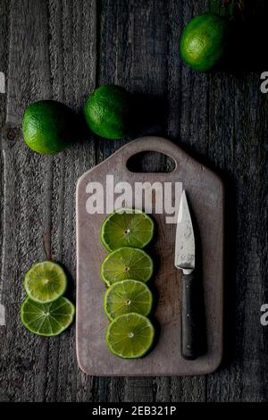 Fette di lime tagliate sul tagliere Foto Stock