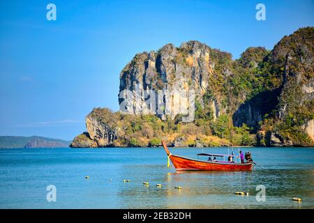 Vista mare con barca a coda lunga e montagna a Riley Beach, provincia di Krabi, Thailandia Foto Stock