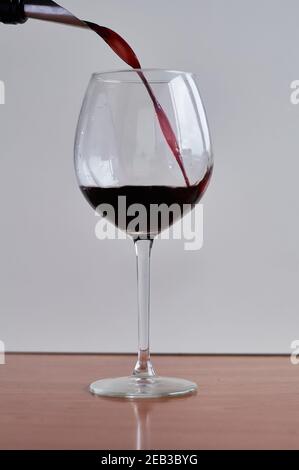 il vino rosso viene versato in un bicchiere Foto Stock