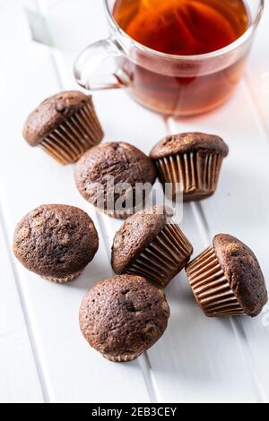 Muffin al cioccolato. Dolci cupcake scuri su tavolo bianco. Foto Stock