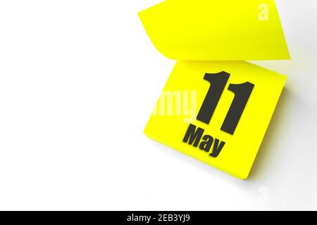 11 maggio . Giorno 11 del mese, data del calendario. Primo piano promemoria carta giallo vuoto Nota adesiva su sfondo bianco. Concetto di mese di primavera, giorno dell'anno Foto Stock