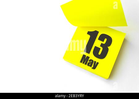 13 maggio. Giorno 13 del mese, data del calendario. Primo piano promemoria carta giallo vuoto Nota adesiva su sfondo bianco. Concetto di mese di primavera, giorno dell'anno Foto Stock