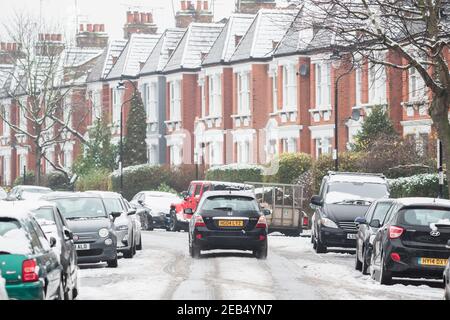 Londra, Regno Unito - 9 febbraio 2021 - un'auto che guida su una strada coperta di neve a Crouch End, condizioni di guida avverse Foto Stock