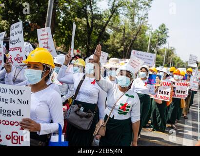 Yangon, Myanmar. 12 Feb 2021. Gli insegnanti marciano per le strade mentre tengono cartelli durante la dimostrazione. Migliaia di persone scesero per le strade di Yangon per protestare contro il colpo di stato militare e chiesero il rilascio di Aung San Suu Kyi. L'esercito del Myanmar ha arrestato il consigliere di Stato del Myanmar Aung San Suu Kyi il 01 febbraio 2021 e ha dichiarato uno stato di emergenza mentre coglie il potere nel paese per un anno dopo aver perso l'elezione contro la Lega nazionale per la democrazia (NLD). Credit: SOPA Images Limited/Alamy Live News Foto Stock