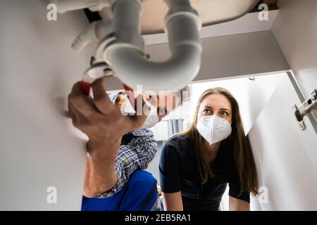 Fissaggio del tubo di scarico bloccato. Riparazione idraulica in maschera facciale Foto Stock