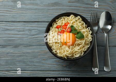 Concetto di cibo gustoso con ciotola di tagliatelle in legno sfondo Foto Stock