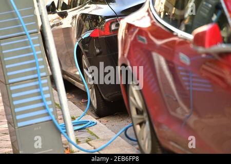 Monaco, Germania. 12 Feb 2021. Immagine dell'argomento espansione dell'infrastruttura di ricarica. Due e-car TESLA vengono addebitate ai posti di ricarica di Monaco nel quartiere Lehel. Auto elettrica in carica, presa di ricarica, cavo di ricarica, e-mobility, elettrificazione. Produttore di auto, auto, automobili, automobili, produttori, industria automobilistica, marchio premium. | utilizzo in tutto il mondo credito: dpa/Alamy Live News Foto Stock
