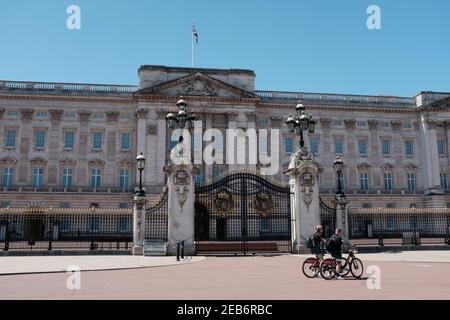 LONDRA - 29 MAGGIO 2020: Buckingham Palace a Londra durante il blocco britannico di Coronavirus. I pedoni sulle biciclette si trovano accanto ai cancelli Foto Stock