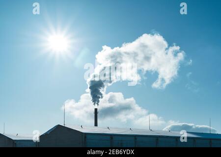 Aria inquinante tubo di fabbrica, fumo da camino contro il sole, problemi ambientali, tema ecologico, scena industriale Foto Stock