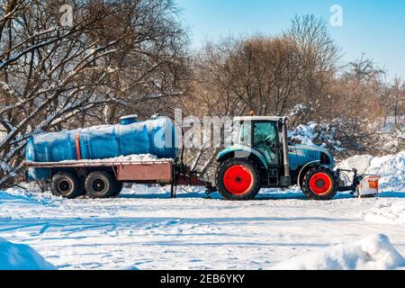 Trattore con autocisterna per la pulizia dell'impianto fognario. Stagione invernale. Foto Stock