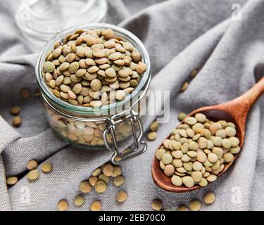 Pila di lenticchie grezze in un vaso di vetro su un tabella Foto Stock