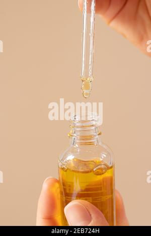 Olio ecologico naturale per il viso in bottiglia di vetro con pipetta. Cosmetologia e cura del viso e del collo. Foto verticale Foto Stock