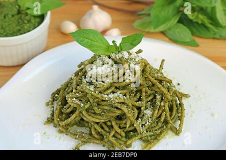 Piatto di delizioso Pesto fatto in casa salsa integrale Spaghetti con fresco Ingredienti in background Foto Stock