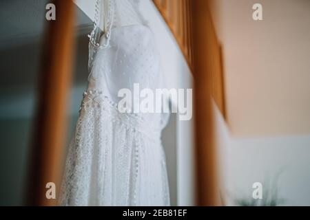 un abito da sposa appeso in camera Foto Stock