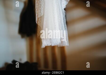 foto di un abito da sposa appeso in camera Foto Stock