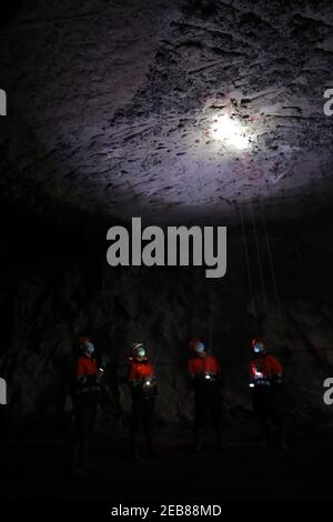 (210212) -- JINCHANG, 12 febbraio 2021 (Xinhua) -- i minatori lavorano sotterranei nella terza zona mineraria del gruppo Jinchuan a Jinchang, nella provincia di Gansu, nella Cina nord-occidentale, il 11 febbraio 2021. Nella miniera buia a più di 600 metri di profondità, le macchine minerarie girano e il minerale sul nastro trasportatore risplende di lucentezza metallica. È la terza zona mineraria del gruppo Jinchuan di Jinchang, una delle principali basi di produzione del paese di nichel, cobalto e rame. I lavoratori qui che non hanno fatto ritorno a casa durante il Festival di primavera si sono attaccati ai loro posti per garantire l'attività mineraria in modo ordinato. (XI Foto Stock