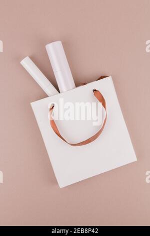 una borsa di carta del negozio con cosmetici su bianco sfondo Foto Stock