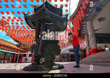 Kuala Lumpur, Malesia. 12 Feb 2021. Un uomo prega il primo giorno del Capodanno cinese lunare in un tempio a Kuala Lumpur, Malesia, 12 febbraio 2021. Credit: Chong Voon Chung/Xinhua/Alamy Live News Foto Stock