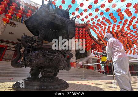Kuala Lumpur, Malesia. 12 Feb 2021. Un membro del personale spray disinfettante il primo giorno del Capodanno cinese lunare in un tempio a Kuala Lumpur, Malesia, 12 febbraio 2021. Credit: Chong Voon Chung/Xinhua/Alamy Live News Foto Stock