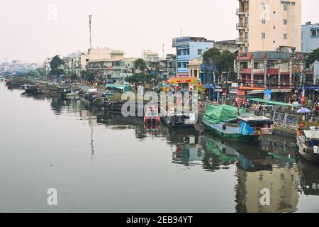 Mercato dei fiori su un fiume nella città di ho Chi Minh, Vietnam. I commercianti che mostrano i loro fiori sulle barche per i clienti da acquistare. Febbraio 2021. Foto Stock