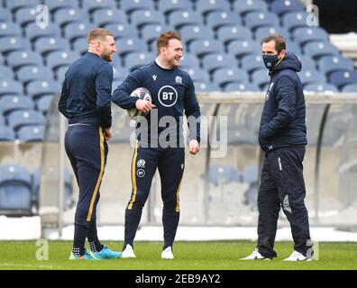 BT Murrayfield Stadium, Edinburgh.Scotland UK.12th Feb 21. Scozia sessione di allenamento Rugby Squad per la partita Guinness Six Nations vs Galles Pic mostra Scozia Finn Russell (Racing 92) & Captain Stuart Hogg (Exeter Chiefs) chattando con l'allenatore di assistenza Chris Paterson Credit: eric mcowat/Alamy Live News Foto Stock