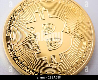 Moneta Bitcoin dorata con criptovaluta fisica su alluminio spazzolato Foto Stock
