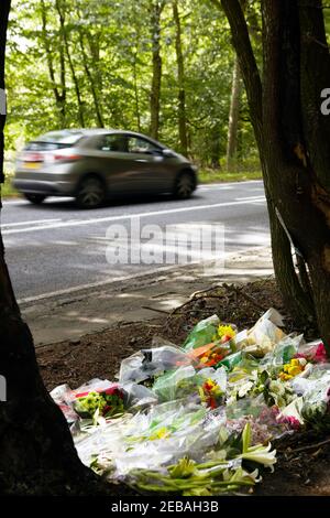 Tributi floreali a scena di incidente fatale su Busy Road Con auto veloce Foto Stock