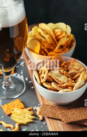 Bicchiere di birra scura con ciotola di spuntini alla birra vicino su Foto Stock