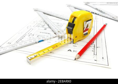 Attrezzature per utensili da lavoro disposte su piani di costruzione della casa con metro a nastro, matita e righello in legno. Foto dello studio di ripresa isolata su sfondo bianco Foto Stock