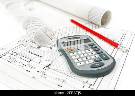 Primo piano di calcolatrice e matita collocati su piani di miglioramento domestico con rotoli di disegni architettonici. Scattare foto isolate su sfondo bianco. Foto Stock